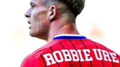 Why does Robbie Ure have first name on his Scotland shirt?
